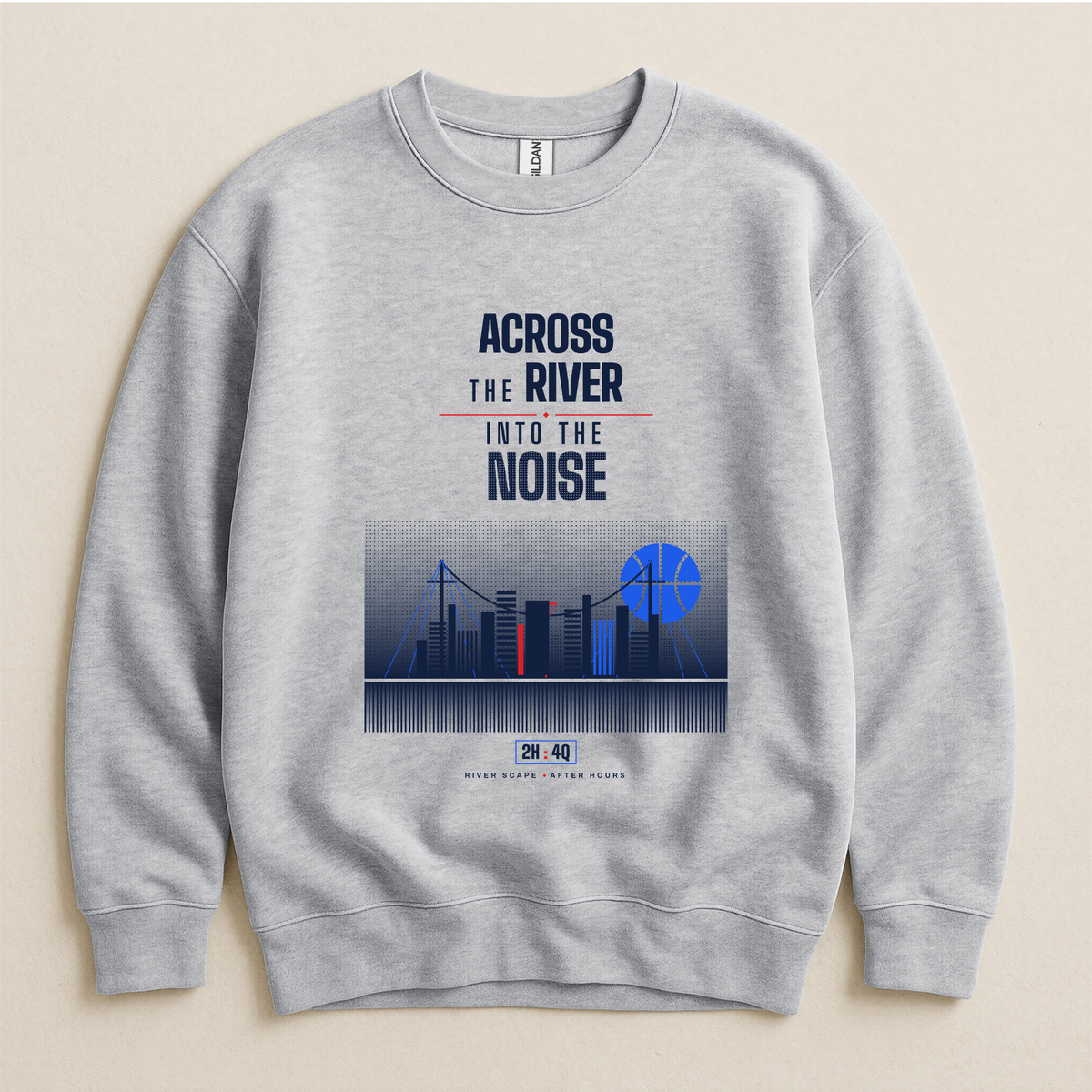 A light gray crewneck sweatshirt with a graphic print on the front. The print features the text 'ACROSS THE RIVER INTO THE NOISE' in navy and red, above a stylized city skyline illustration with a blue basketball shaped moon.