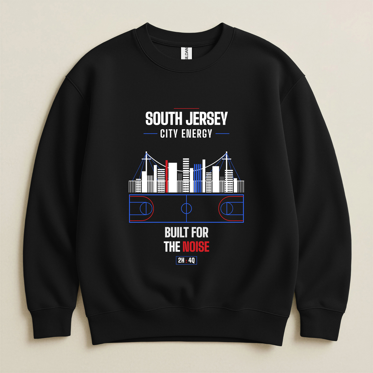 A black crewneck sweatshirt with a graphic print of a basketball court and city skyline, featuring the text 'SOUTH JERSEY CITY ENERGY' and 'BUILT FOR THE NOISE' in white and red, displayed on a light beige background.